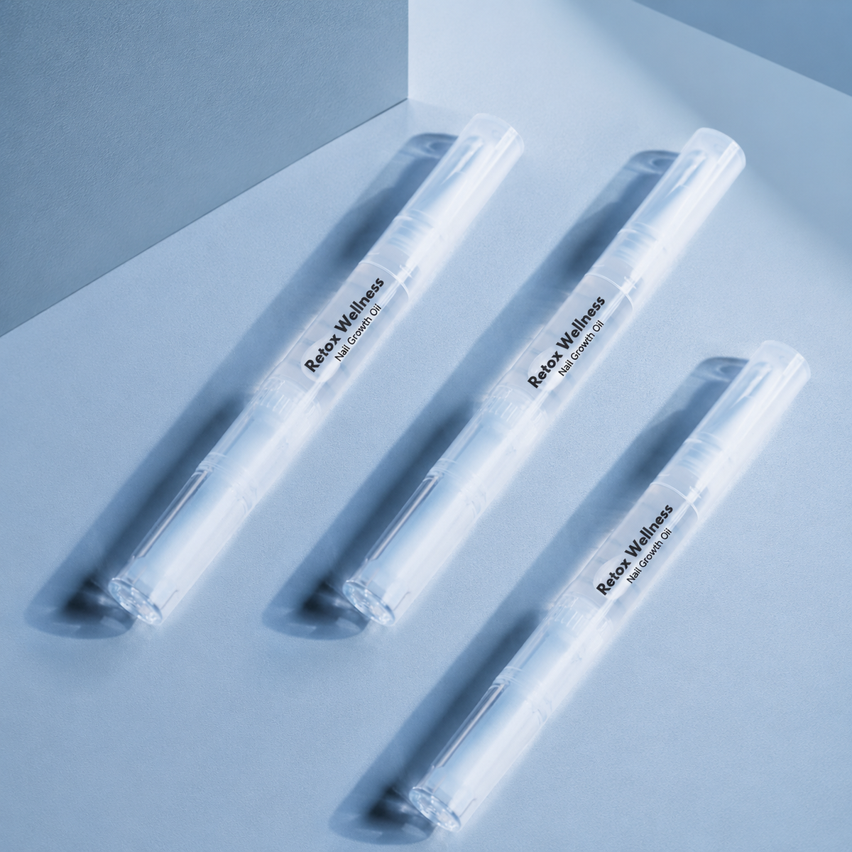 Three clear cylindrical cosmetic tubes labeled 'Roxi Wellness' arranged diagonally on a cool blue-gray
