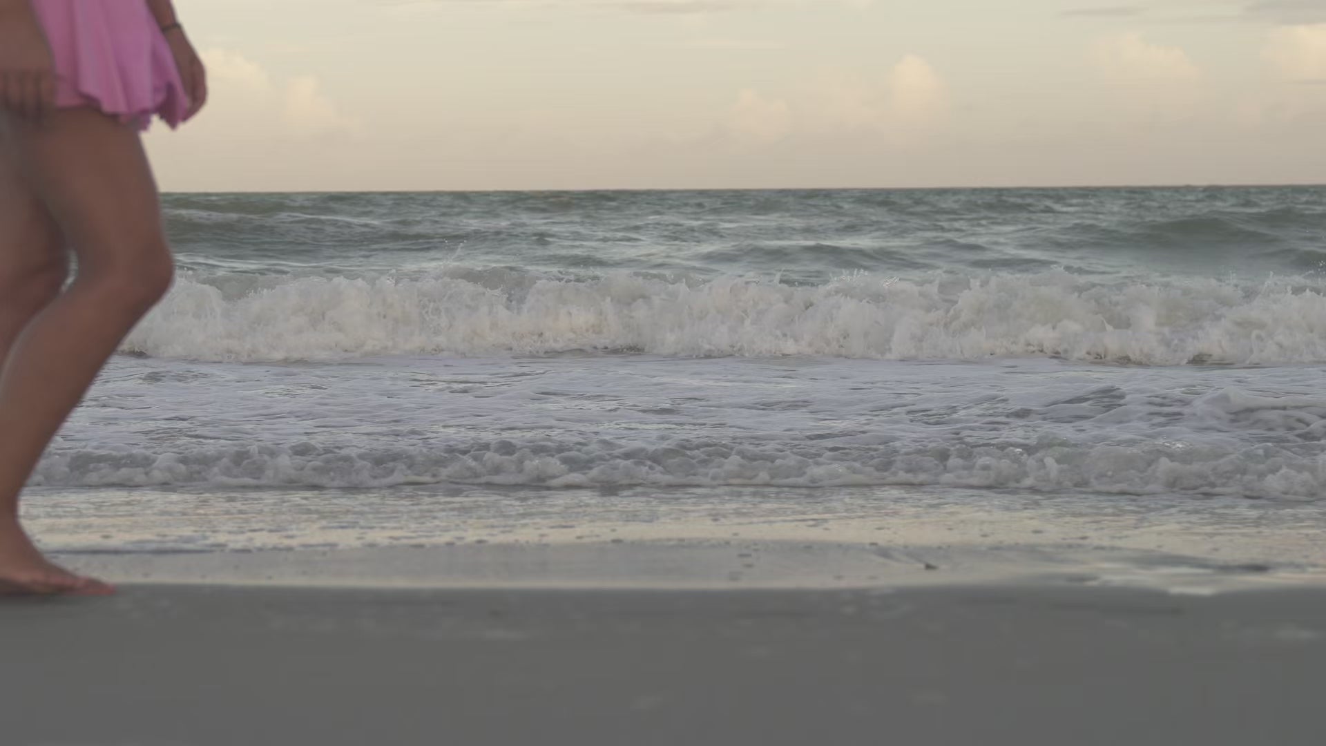 The photo depicts a woman is moving in the sea wearing pink skirtin the sea. 